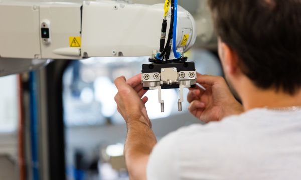 [Translate to Englisch:] Montage eines Robotergreifers in einer Automatisierungsanlage