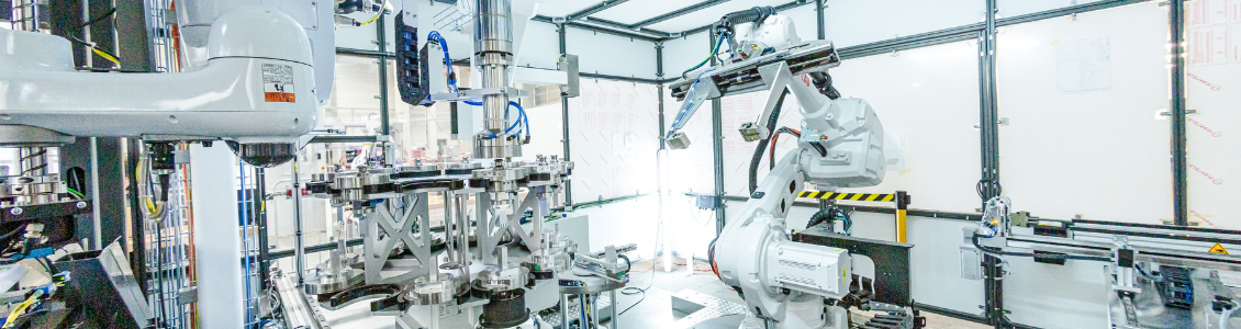 [Translate to Englisch:] Automatisierte Rundtaktanlage mit mehreren Industrierobotern in einer hochmodernen Produktionsumgebung