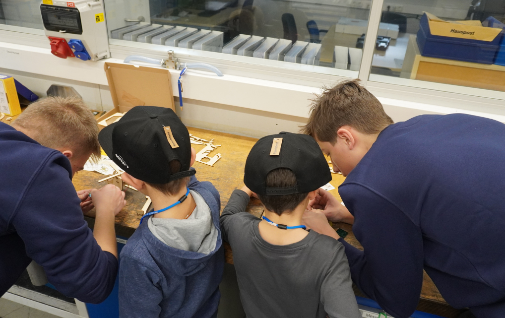 Kinder bauen gemeinsam Holzbausätze an einer Werkbank beim Kids Day bei esmo