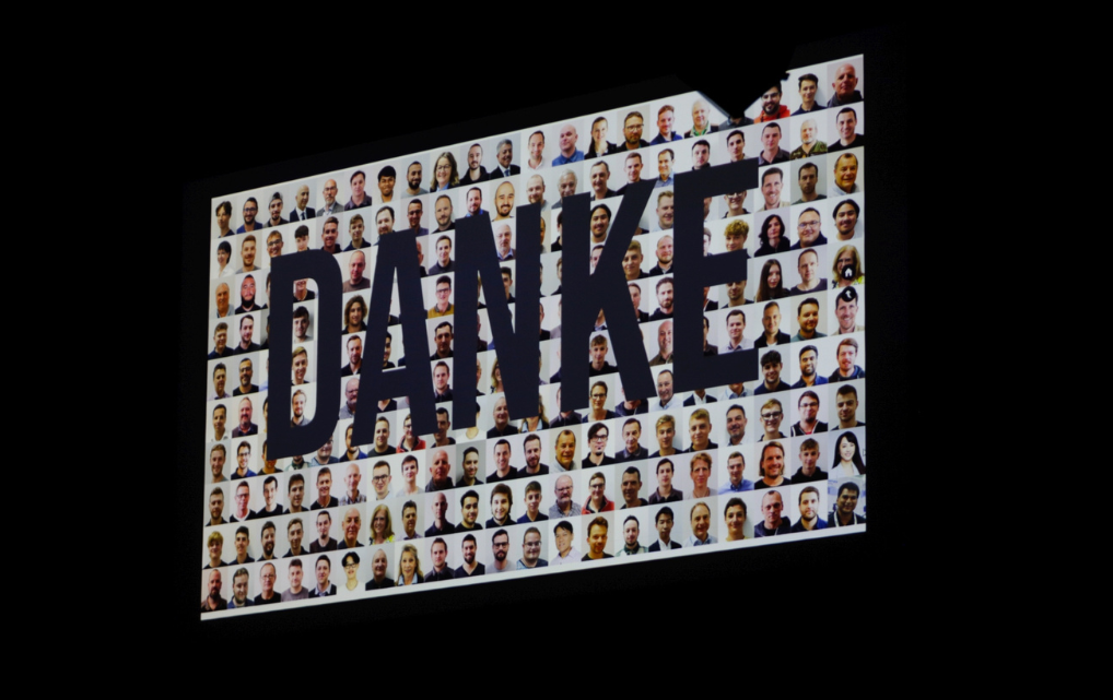 Projection showing the word “DANKE” and portraits of numerous esmo employees during the anniversary celebrations
