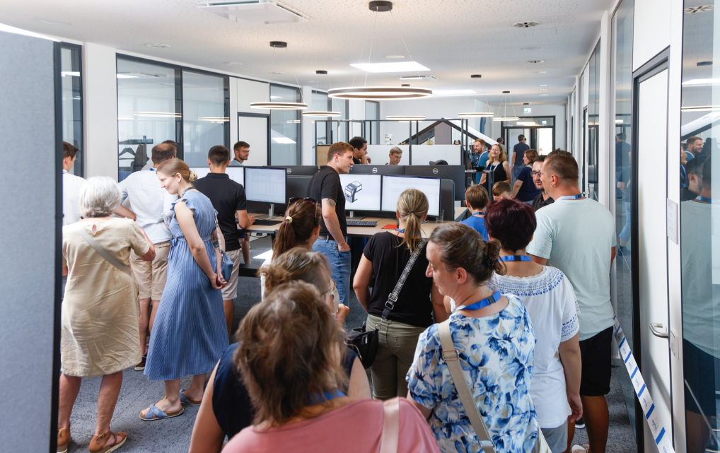 Visitors learn about esmo AG’s work in an engineering and development area.