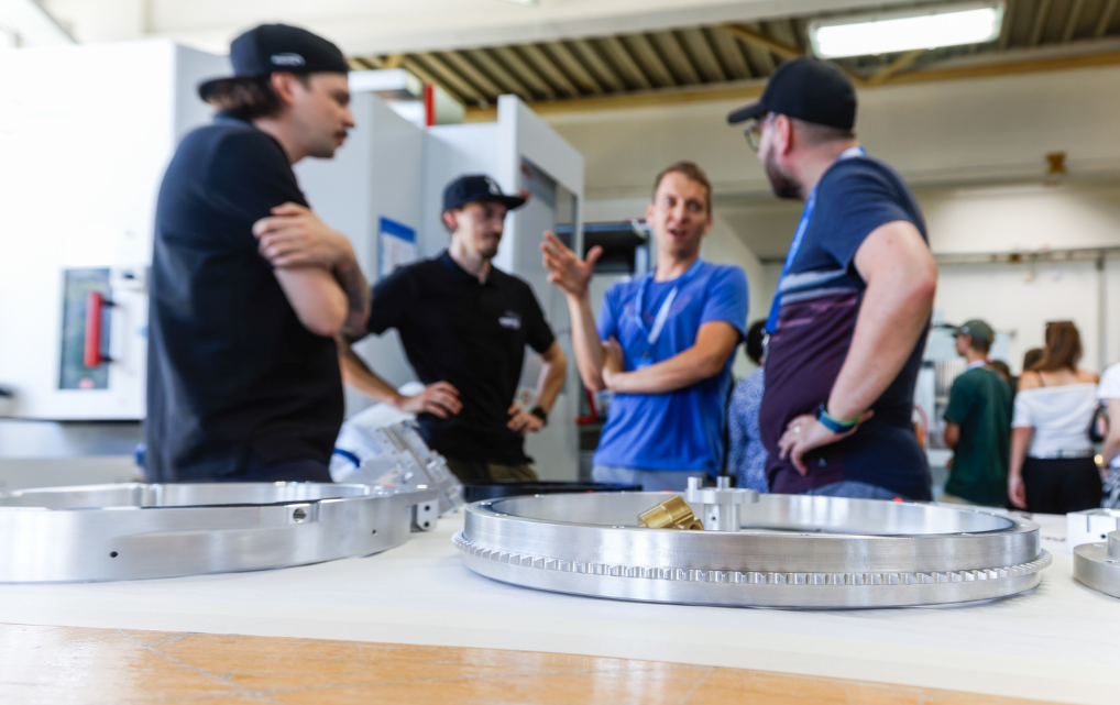 Employees and visitors discuss components and manufacturing during esmo AG’s Open House.