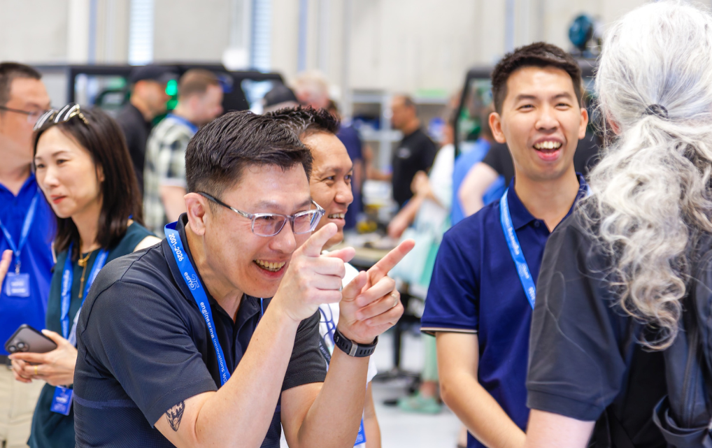 International esmo employees exchange ideas during the Open House in a technical working area.