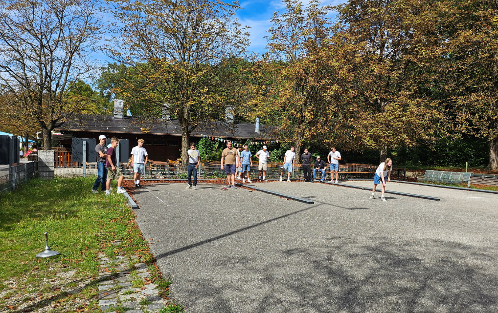 Azubis der esmo group beim Eisstockschießen im Hopfengarten, mehrere Teams im Einsatz.