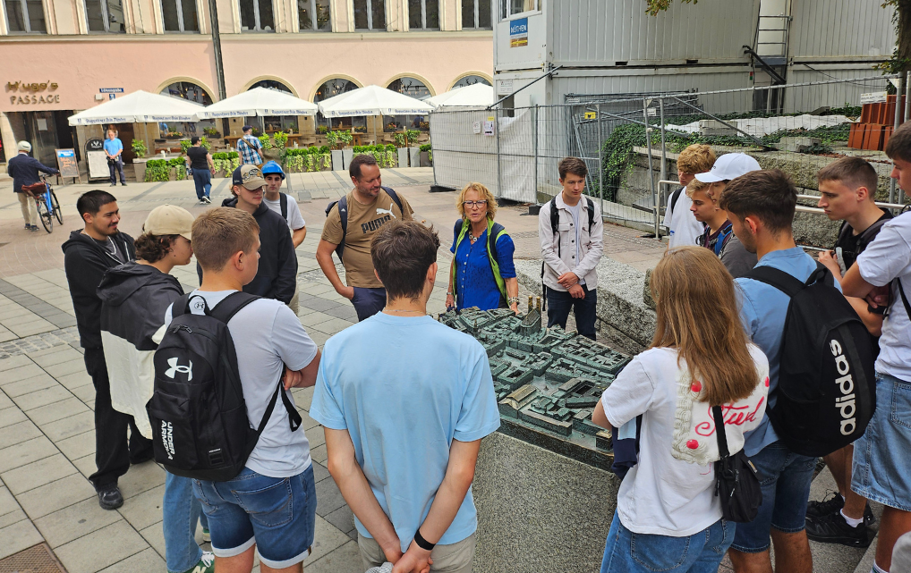 Azubi-Gruppe der esmo group hört der Stadtführerin am Stadtmodell München zu.