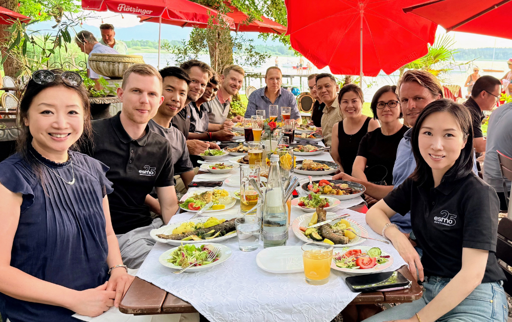International esmo colleagues having lunch together at a lakeside restaurant.