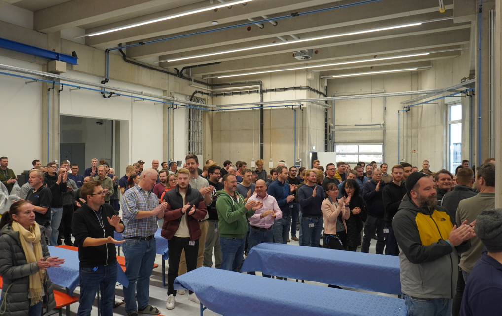 Mitarbeitende der esmo AG bei einer Ansprache zum Soft Opening im neuen Firmengebäude