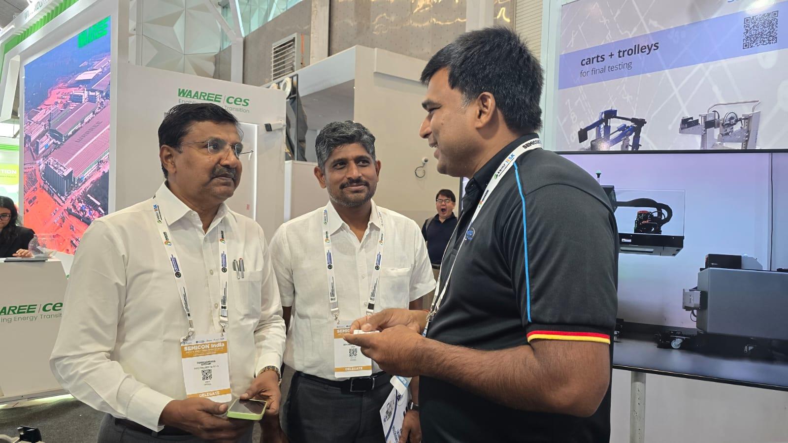 esmo semicon Teammitglied im Gespräch mit Besuchern am Stand auf der SEMICON India 2025 – Austausch über Test- und Handlinglösungen für Halbleiter.