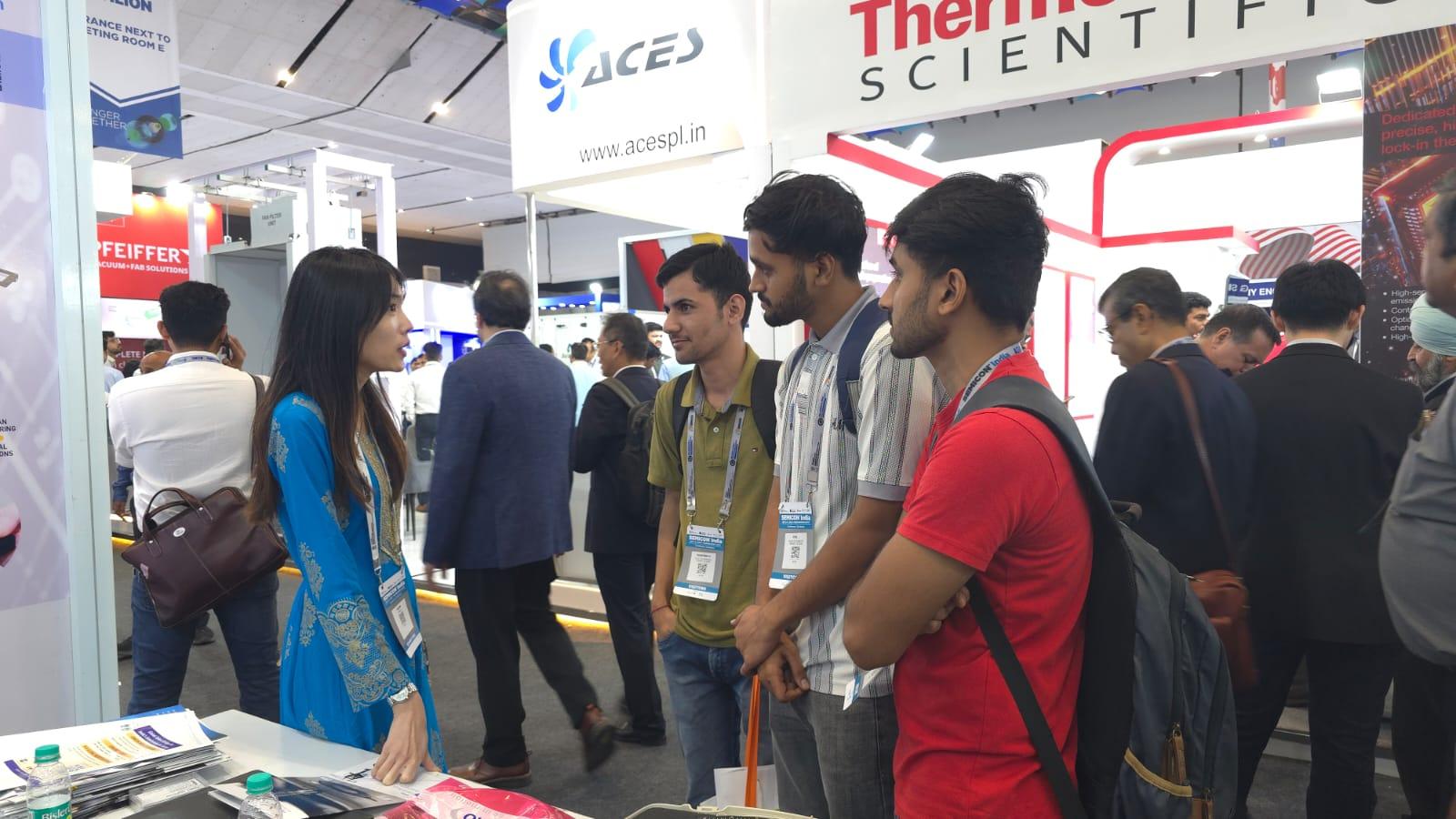 esmo semicon Mitarbeiterin Miya Chng im Austausch mit Besuchern auf der SEMICON India 2025 – Präsentation von Lösungen für Halbleitertests.