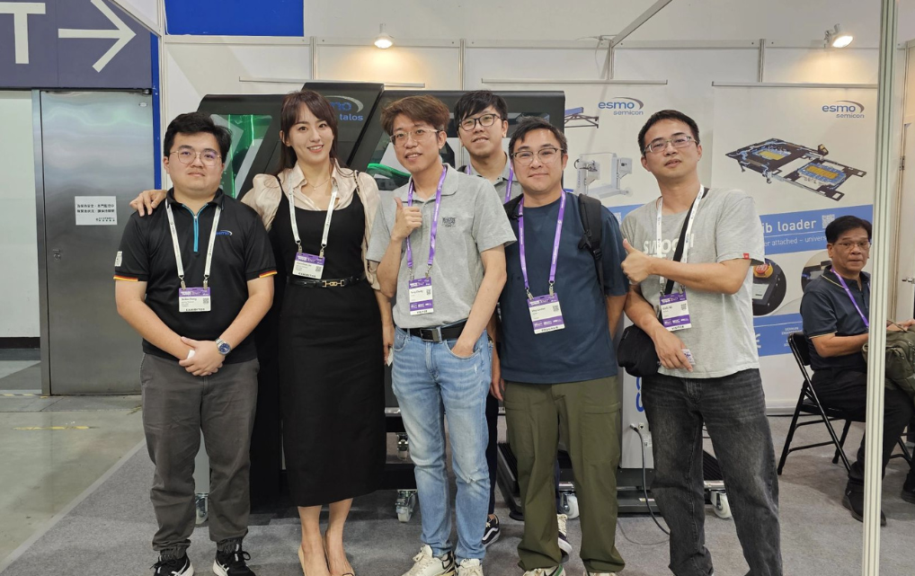 Gruppenfoto mit Besuchern und esmo semicon Teammitgliedern vor dem talos Engineering-Handler auf der SEMICON Taiwan 2025.