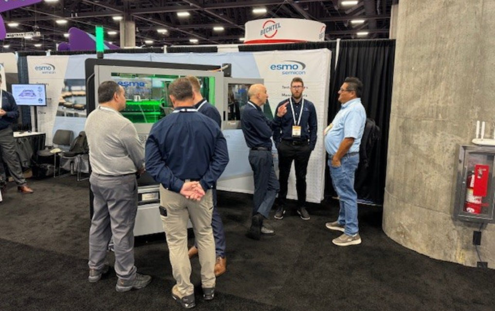 Intensive Fachgespräche neben dem apollo Quad Handler am esmo Stand während der SEMICON West 2025.